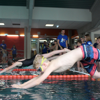 Start einer Freistilstaffel mit Sprung ins Wasser von zwei Schwimmer:innen