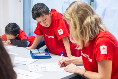 Eine Frau hilft einem Kind beim Lernen