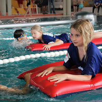 Blick auf alle zwei Bahnen im Rahmen der Rettungsstaffel mit Kindern beim Retten mit der Luftmatratze im Rahmen des Pinguin Cups 2023