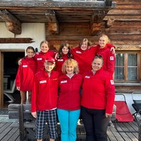 Die Mitglieder der Jugendgruppe Graz-Stadt stehen vor einer Almhütte und lächeln in die Kamera