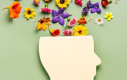 Grafik eines Kopfes mit bunten Blumen vor hellgrünem Hintergrund