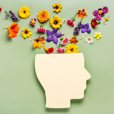 Grafik eines Kopfes mit bunten Blumen vor hellgrünem Hintergrund