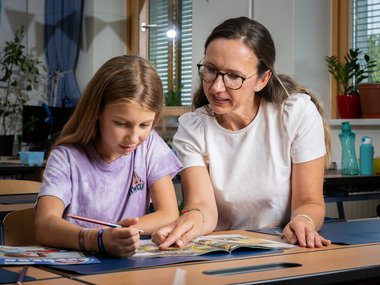 Eine Lehrerin und eine Schülerin lesen