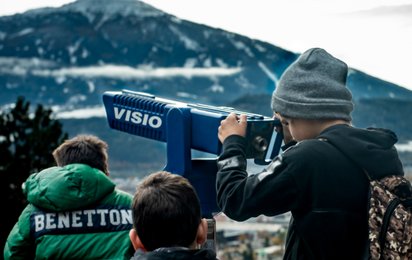 Drei Kinder schauen auf die fernen Berge.