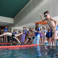 Kinder springen zum Staffelstart ins Wasser beim Pinguin Cup 2023