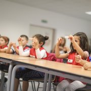 Kinder sitzen in einer Reihe und lernen Pflaster kleben